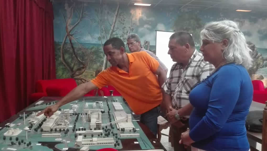 Arnolis Almeida señalando la maqueta de la industria nuevitera.