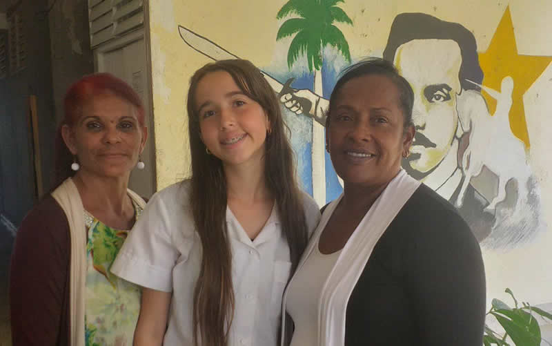 Emelyn Alejandra Fatela Sánchez junto a su profesora Zoraida Robert Sorriba (a la izquierda) y la directora Mayelyn Álvarez Infantes (a la derecha). 